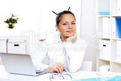 Young beautiful woman in business wear at work