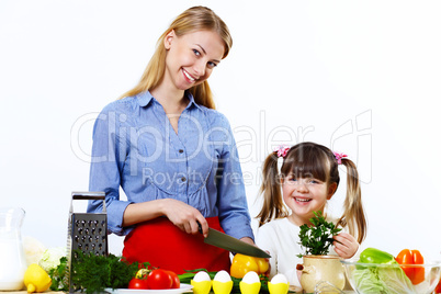 Young mother cooking at home with her daoghter