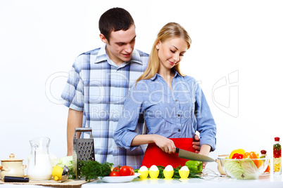 Husband and wife together coooking at home