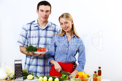 Husband and wife together coooking at home