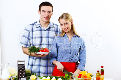 Husband and wife together coooking at home