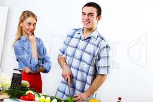 Husband and wife together coooking at home