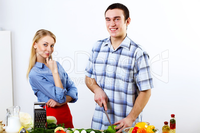 Husband and wife together coooking at home