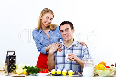 Husband and wife together coooking at home