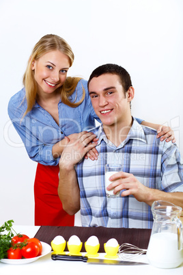 Husband and wife together coooking at home