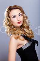 Young woman in black dress with curly hair