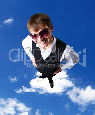 Young businessman against cloudy sky background