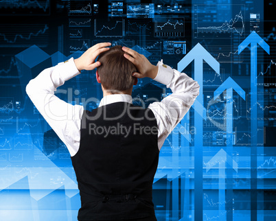 Young businessman against financial graphs