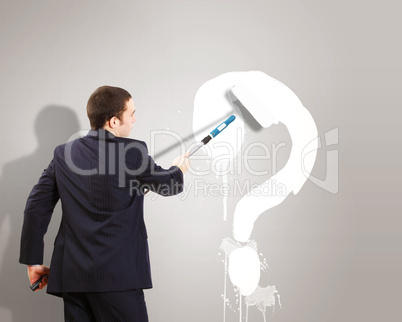 Businessman with paint brash and question mark