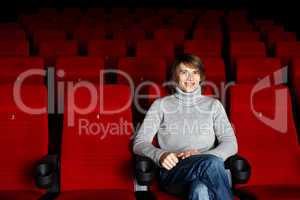 Young man sitting in the cinema alone