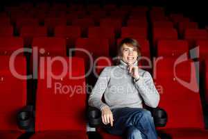 Young man sitting in the cinema alone