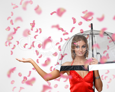 Pretty woman under umbrella with petals around her