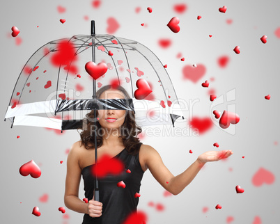 Pretty young woman with umbrella and hearts