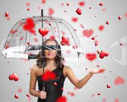 Pretty young woman with umbrella and hearts