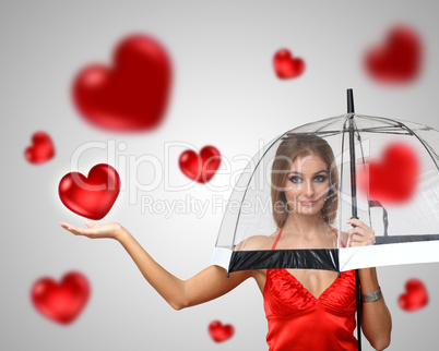 Pretty young woman with umbrella and hearts