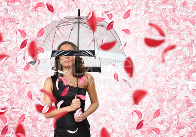 Pretty woman under umbrella with petals around her