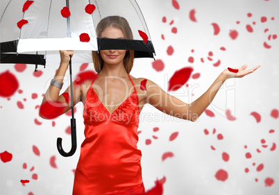 Pretty woman under umbrella with petals around her
