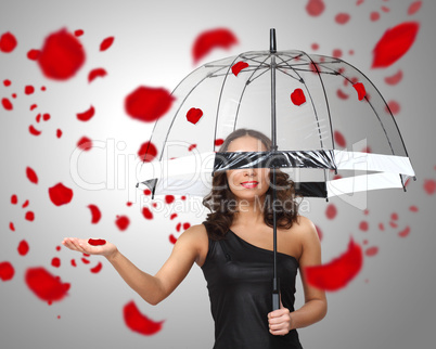 Pretty woman under umbrella with petals around her