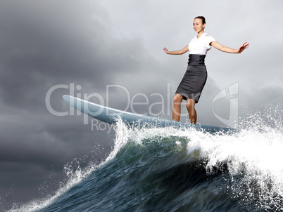 Businesswoman surfing on the sea waves