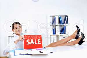 Young woman in business wear with sale sign