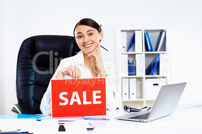 Young woman in business wear with sale sign