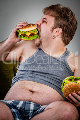 fat man eating hamburger