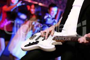 Young guitar player performing in night club