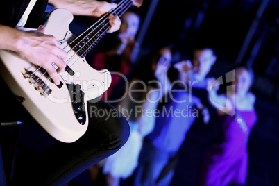 Young guitar player performing in night club