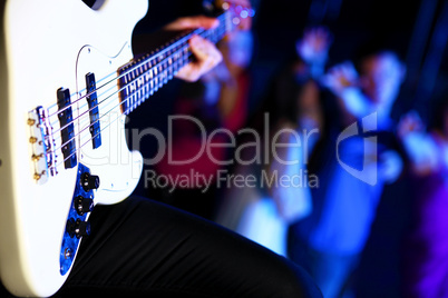 Young guitar player performing in night club