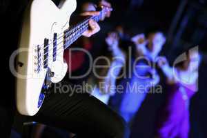 Young guitar player performing in night club