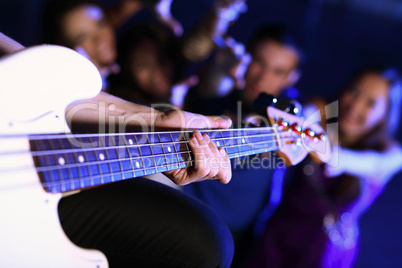 Young guitar player performing in night club