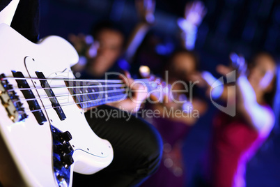 Young guitar player performing in night club