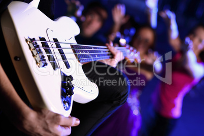 Young guitar player performing in night club