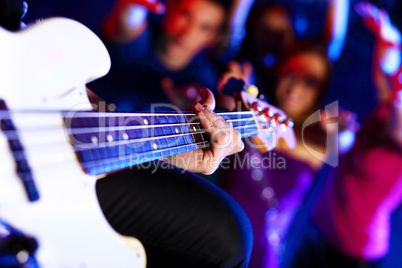 Young guitar player performing in night club