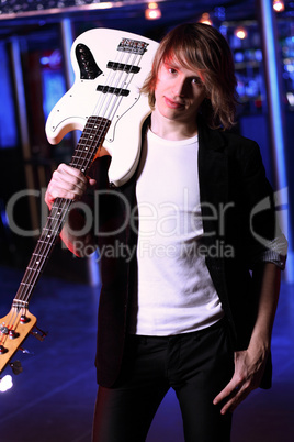 Young guitar player performing in night club