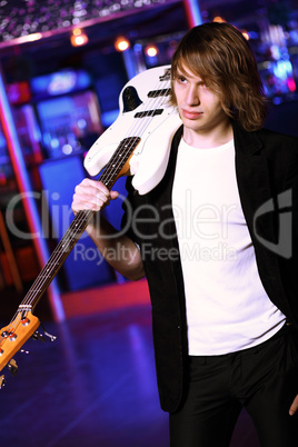 Young guitar player performing in night club