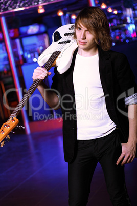 Young guitar player performing in night club