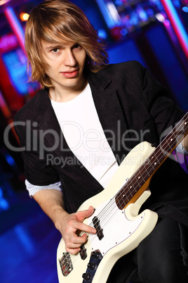 Young guitar player performing in night club