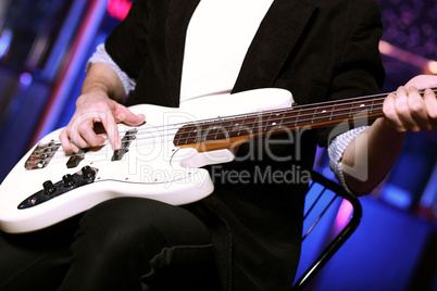 Young guitar player performing in night club