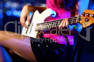 Young guitar player performing in night club