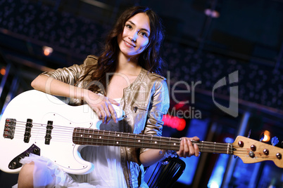 Young guitar player performing in night club