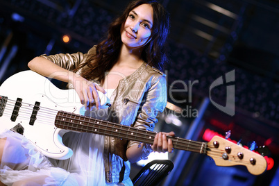 Young guitar player performing in night club