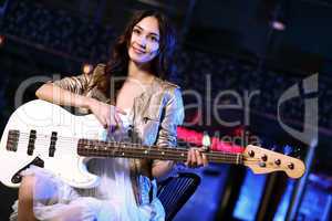 Young guitar player performing in night club