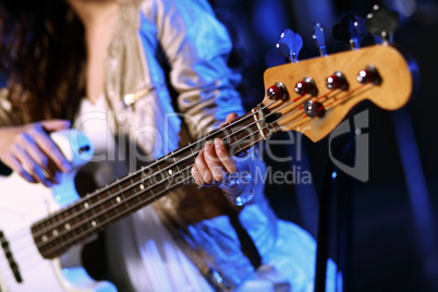 Young guitar player performing in night club