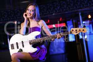 Young guitar player performing in night club