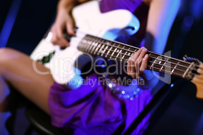 Young guitar player performing in night club