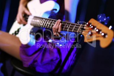 Young guitar player performing in night club