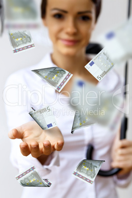 Business woman under money rain with umbrella