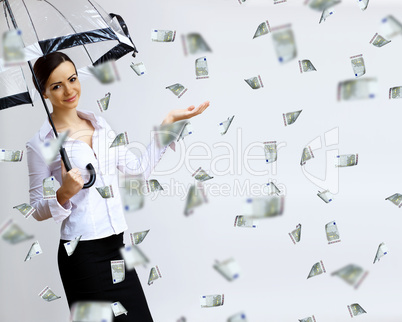 Business woman under money rain with umbrella