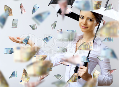 Business woman under money rain with umbrella